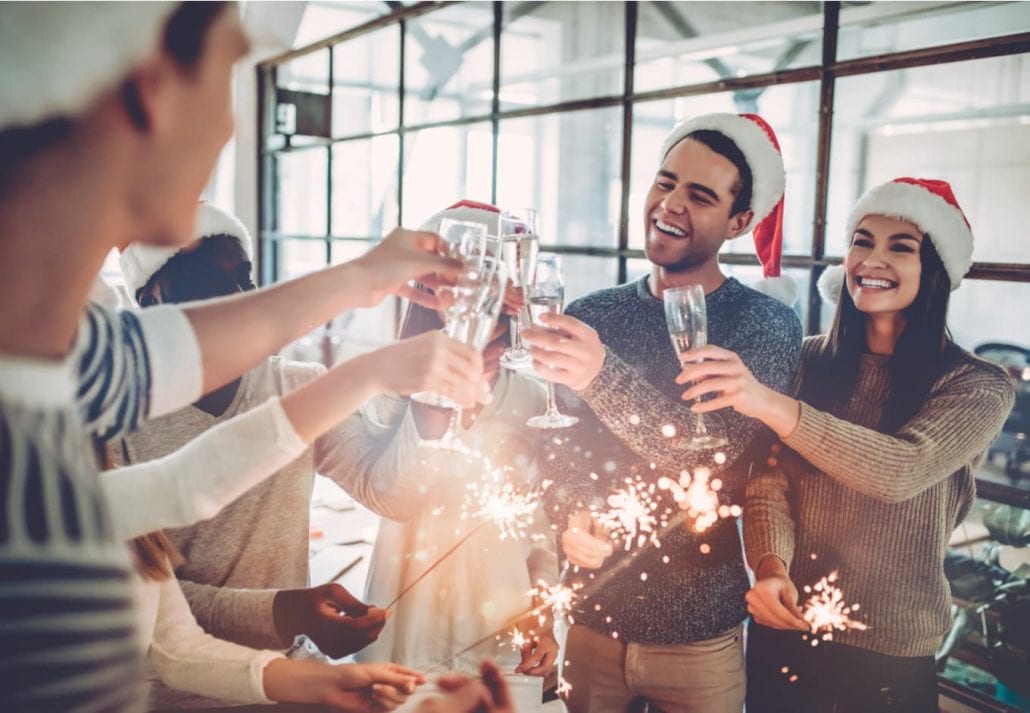 Group of friends celebrating Christmas and drinking Champagne.