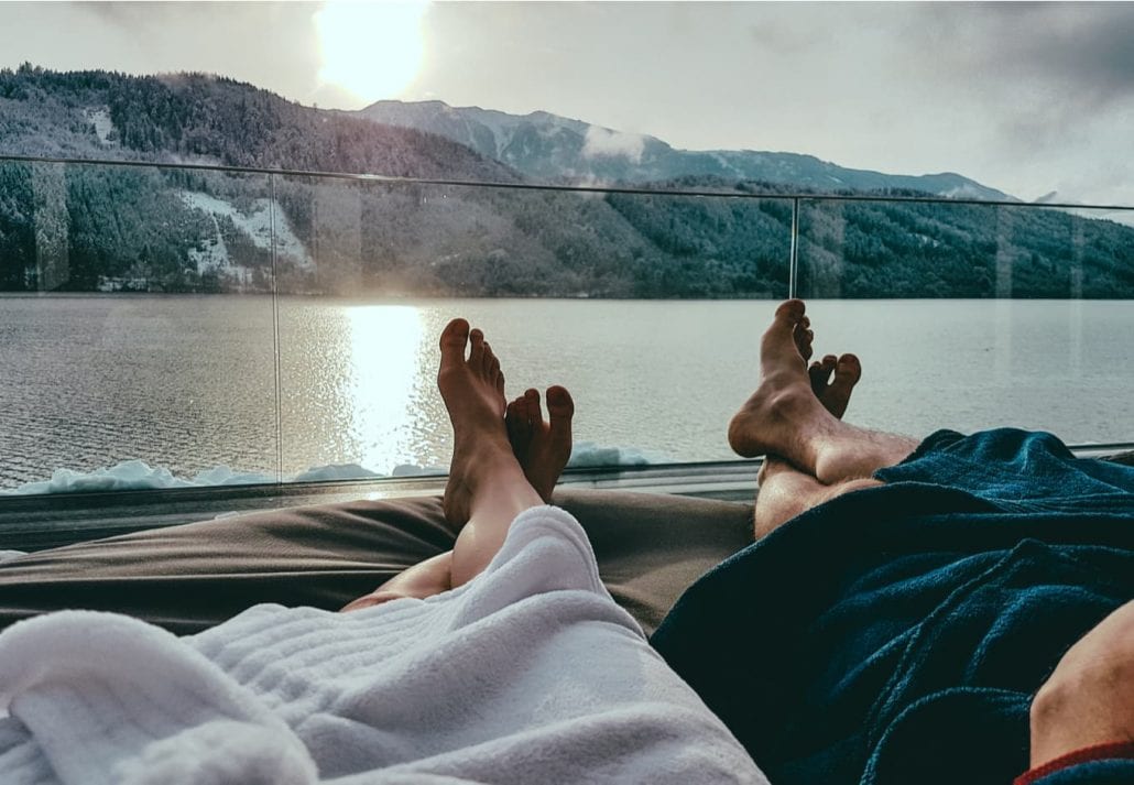 Couple relaxing on the sun beds in Spa, Badehaus Millstätter See, Austria, by Millstätter See.