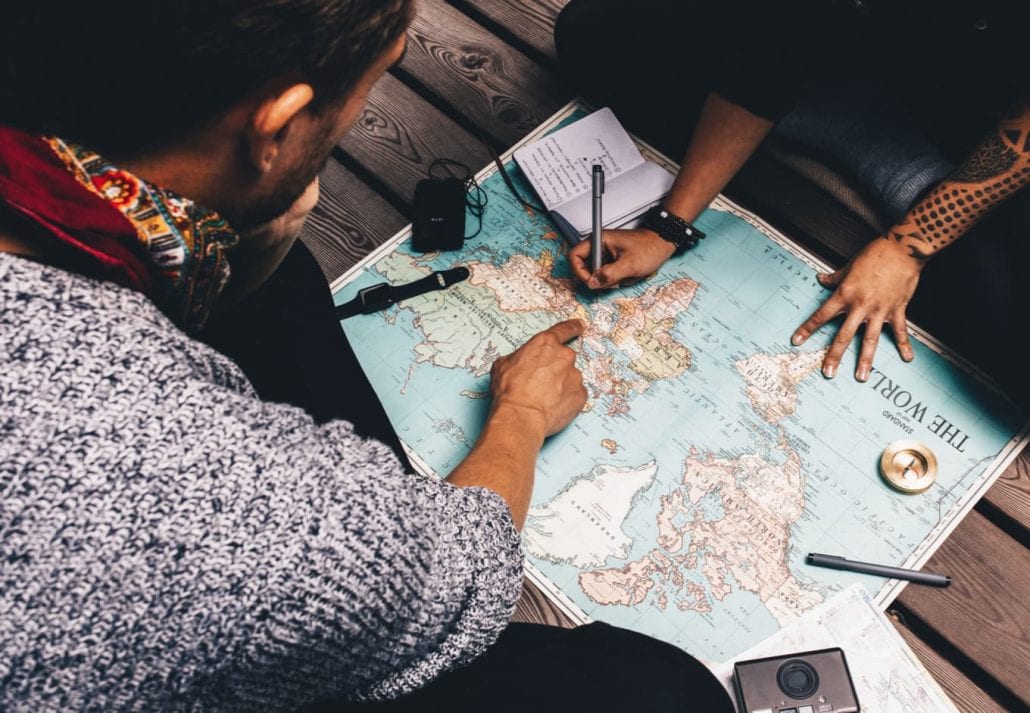 Young couple planning a trip while reading a map.