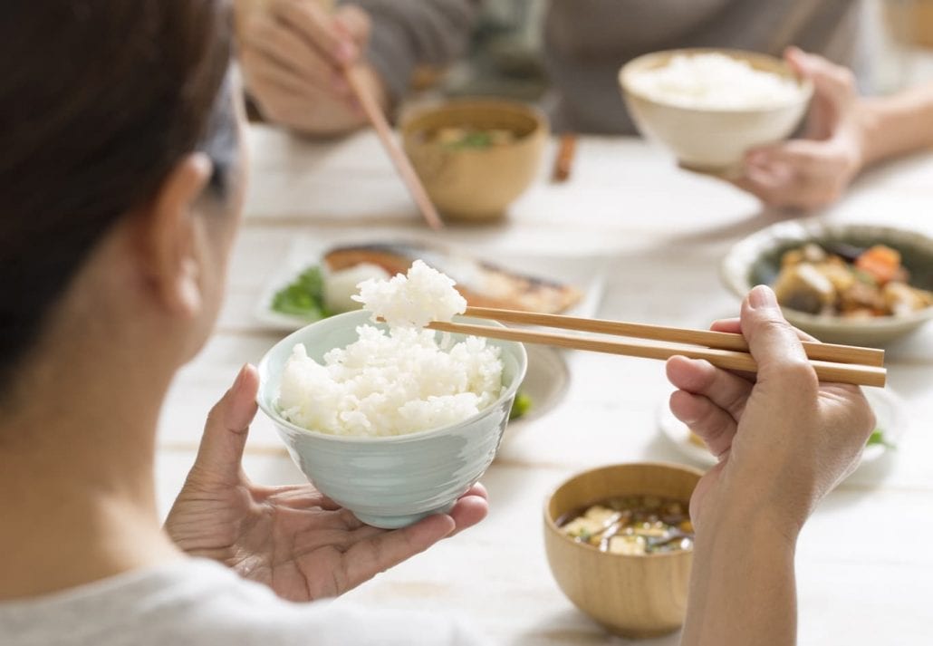 Japanese woman eating rice during a typical dinner meal.