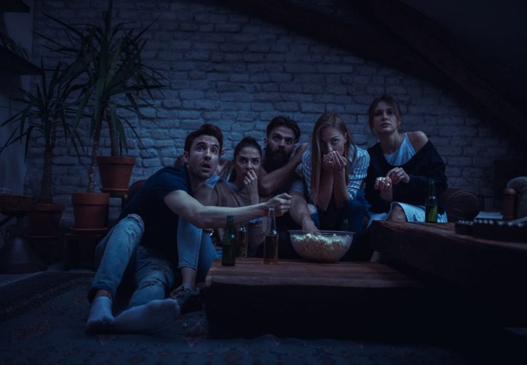 Group of friend watching scary movie at home