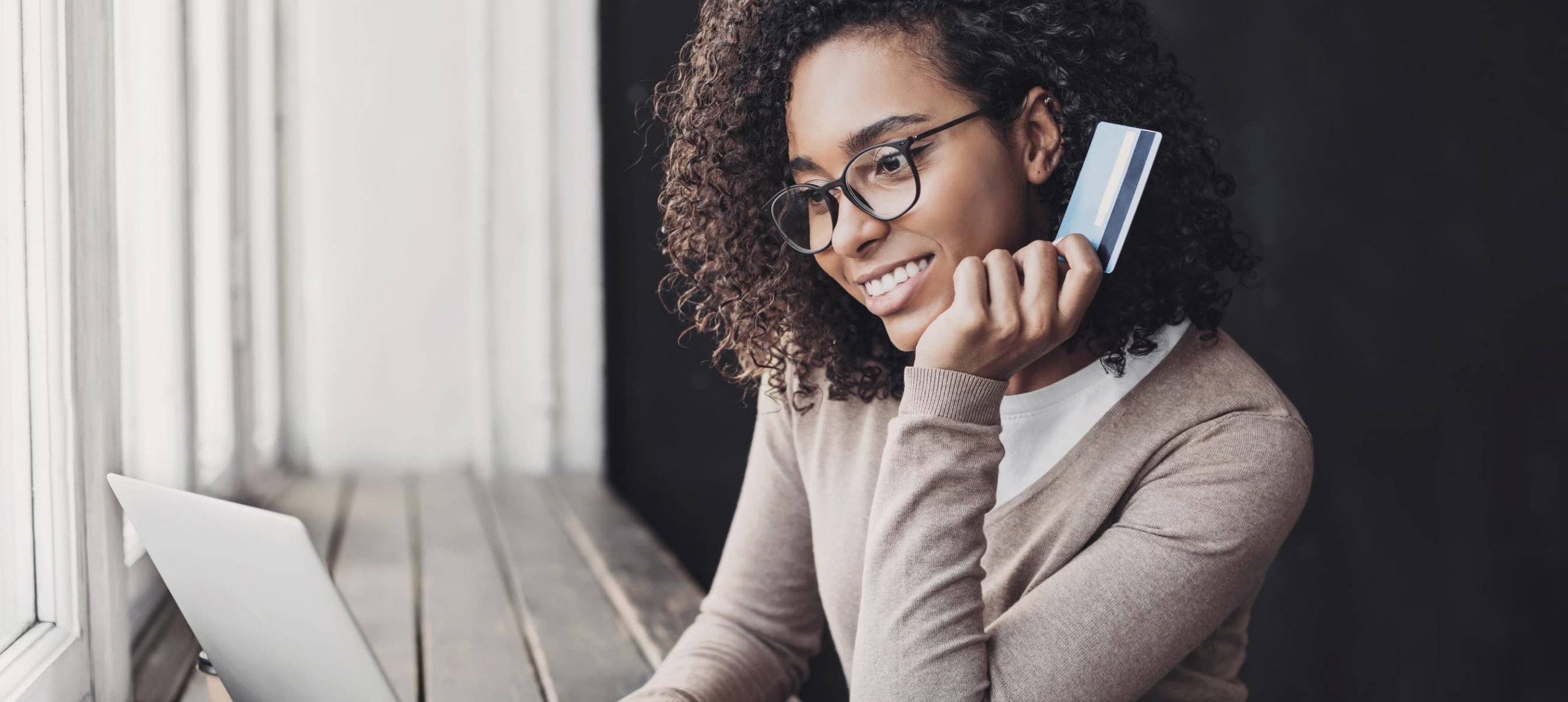 Young woman holding credit card and using laptop making payment online. Businesswoman or entrepreneur working at home. Online shopping, e-commerce, banking, internet store, spending money concept