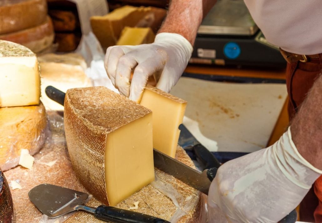 Man cutting slice of cheese.