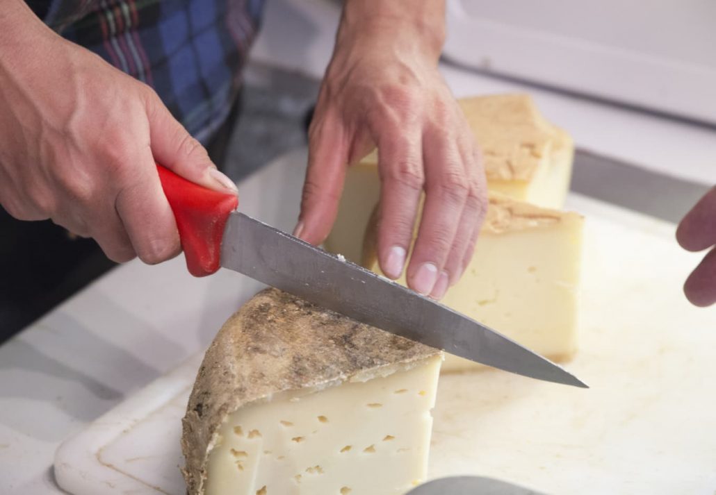 Valle de Roncal landscape in Navarre Spain Cutting farm cheese.