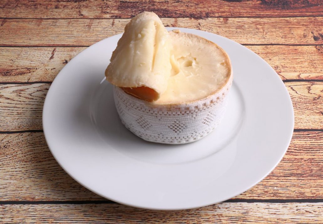 Extremadura cheese (Torta del Casar) on wooden table