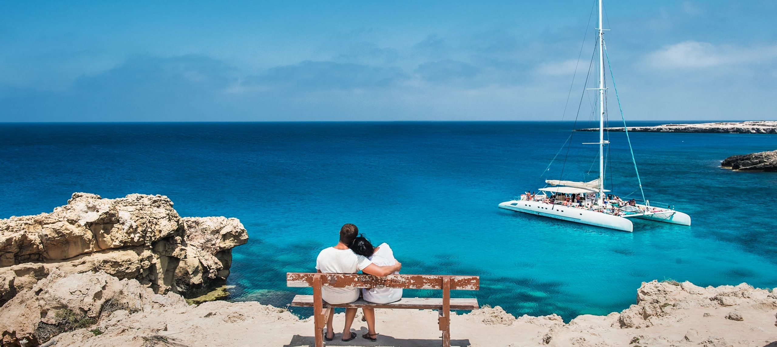 Cpuple looking at the blue ocean at an island.