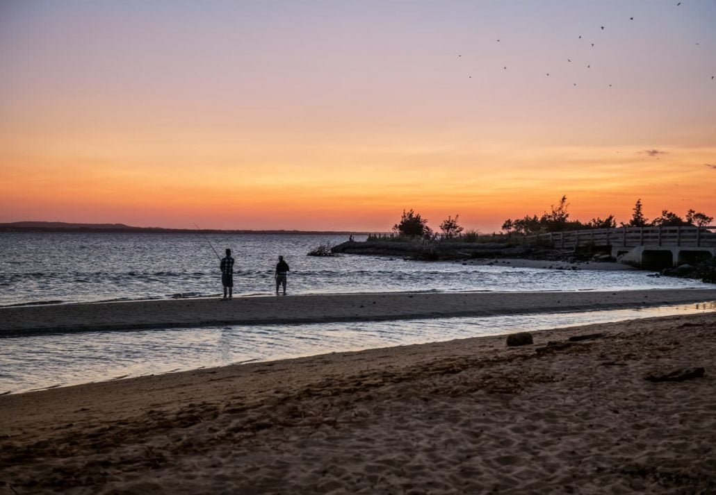 Two men fishing on the bay at sunset on Sandy Hook along the Jersey shore.