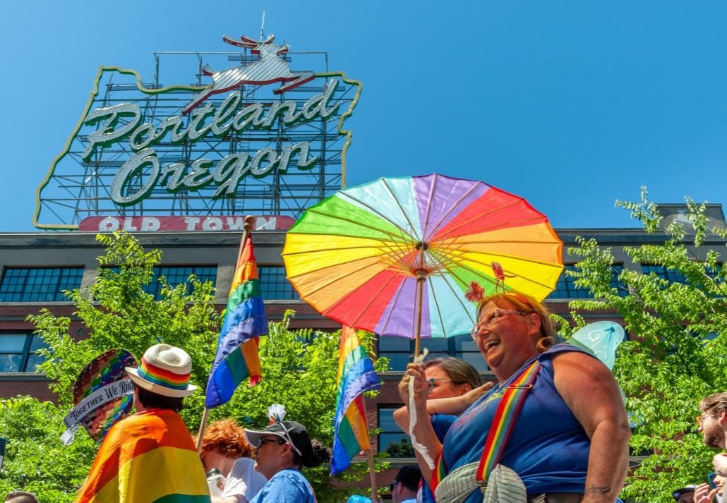 The crowd moves under the famous Portland Sign during the 2018 Pride Parade through the streets of downtown Portland.