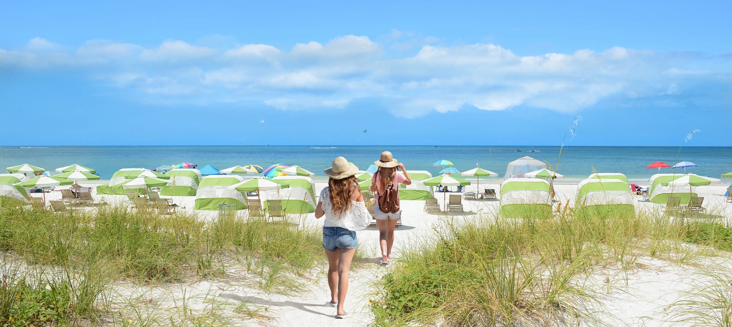 Two girls running on the Clearwater Beach, in Florida, on a sunny day.