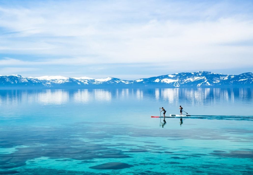 Two people paddleboarding in Lake Tahoe, California.