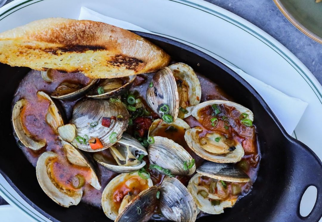 A plate of seafood with a slice of bread on the side.