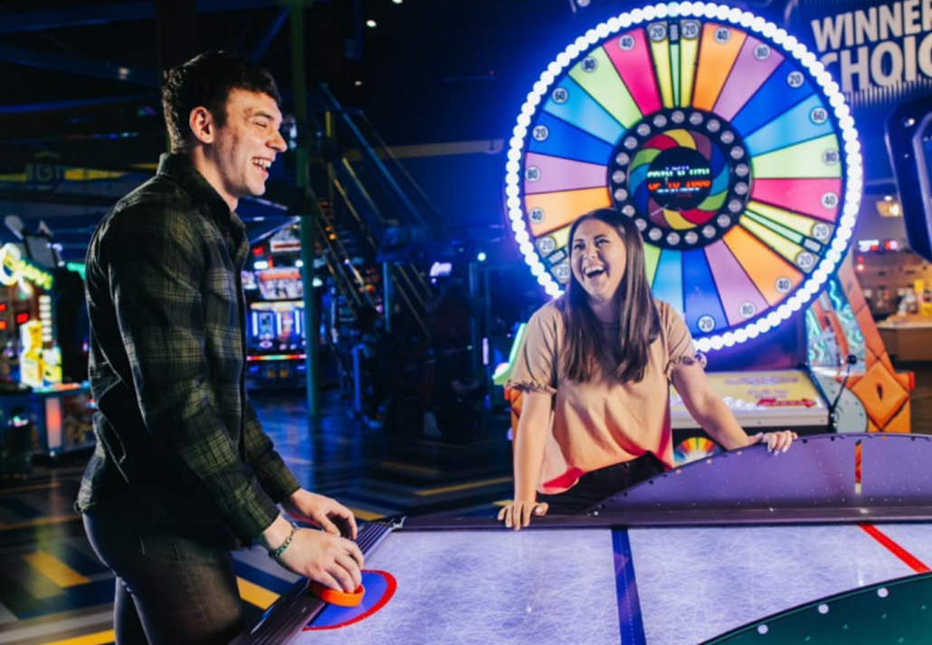 Couple playing games at in an arcade in Pointe Orlando.