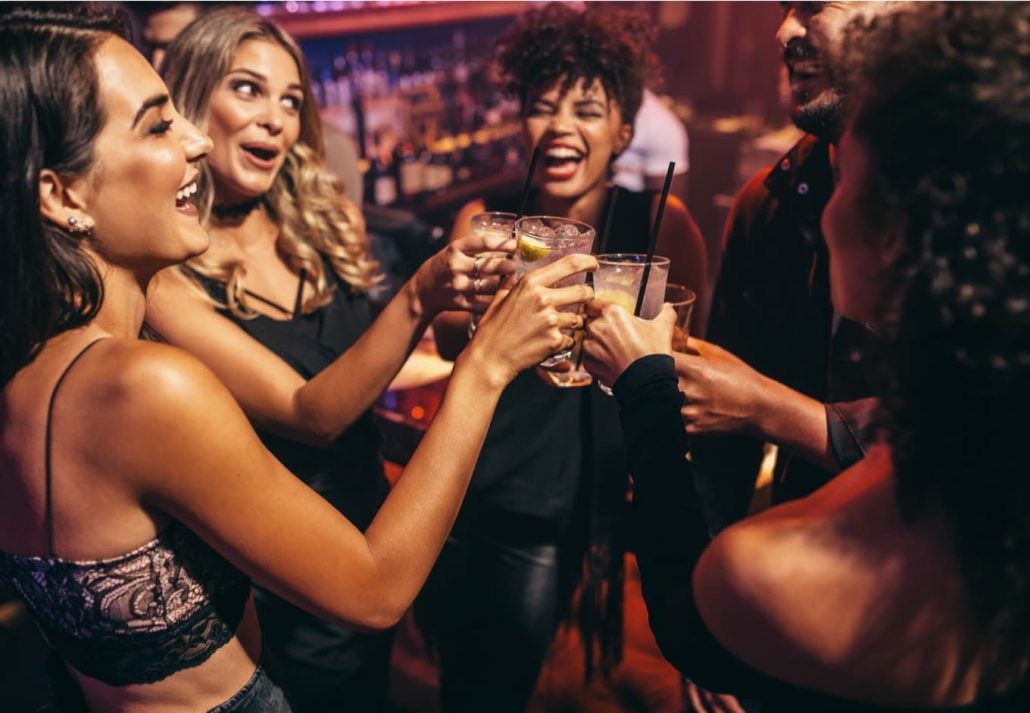Group of friends drinking and laughing at a nightclub
