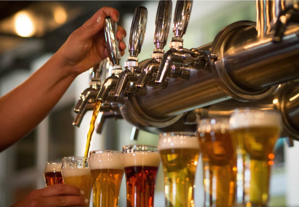 Bartender filling up glasses with craft beer at a bar