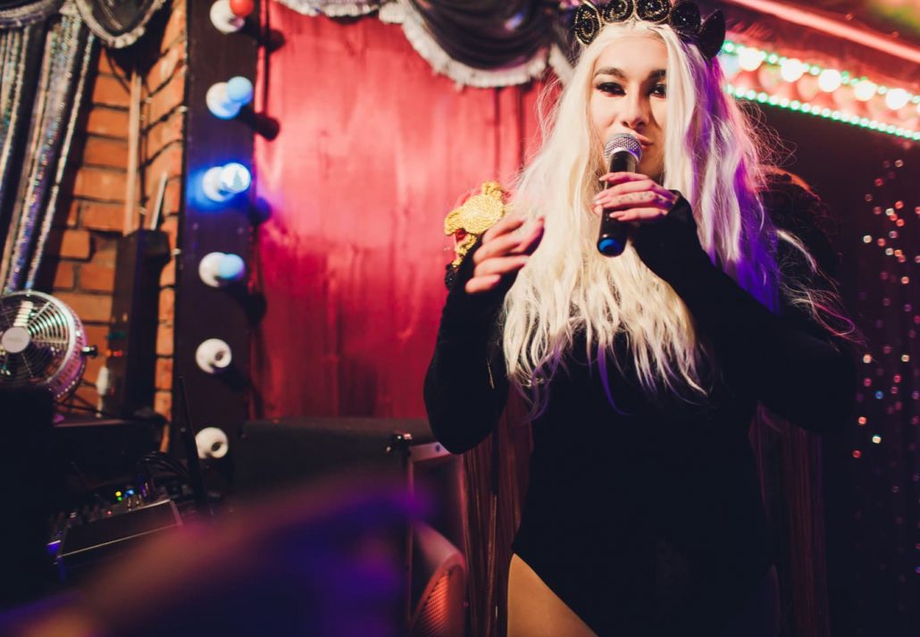 Drag Queen performing at a club at nighttime.