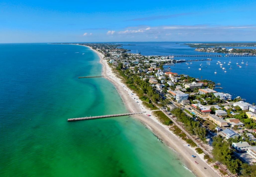 florida-islands-ana-maria-islands | CuddlyNest Travel Blog Aerial view of Cortez beach withe sand beach and his little wood pier on blue water, Anna Maria Island, Florida, USA