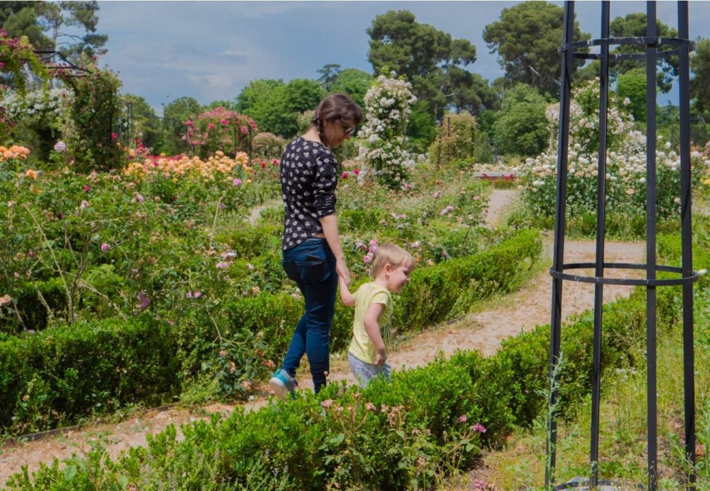 Mother and daugther strolling in a garden in  In El Retiro Park, Madrid, Spain.