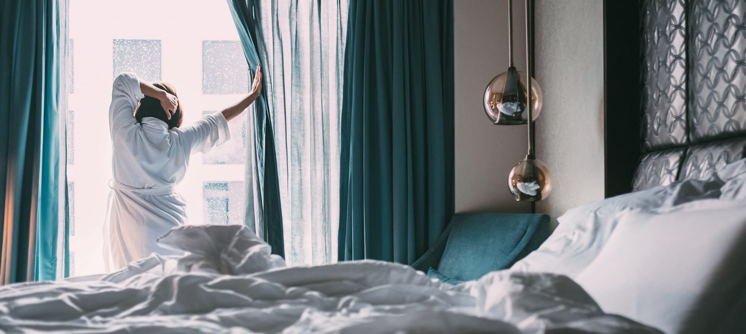 Woman stretching in front of a window in a hotel room.