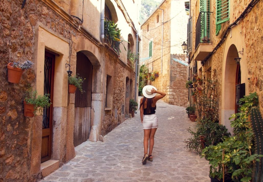 Young woman exploring the narrow streets of Valdemossa, in Mallorca, Spain.