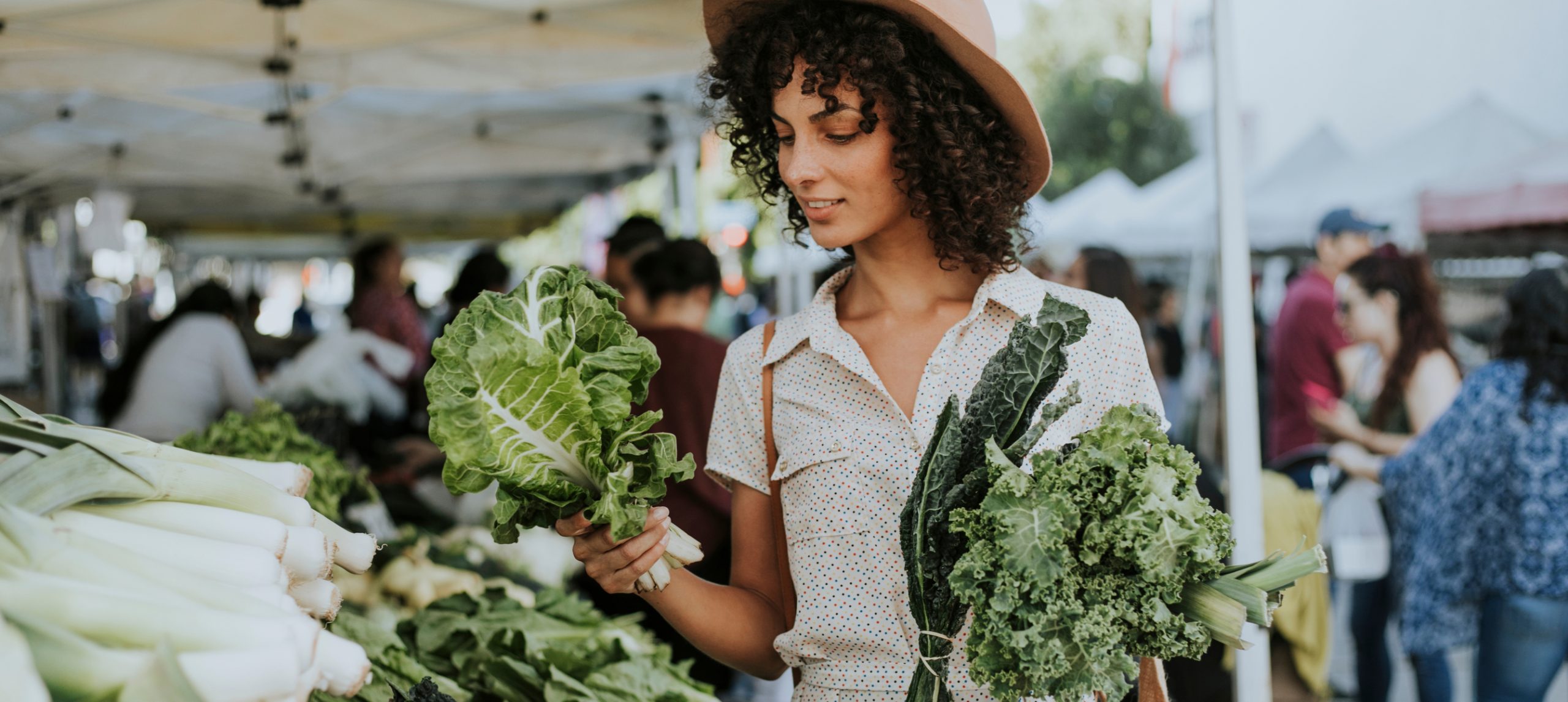 Young woman shopping for vegetables in a farmer's market.