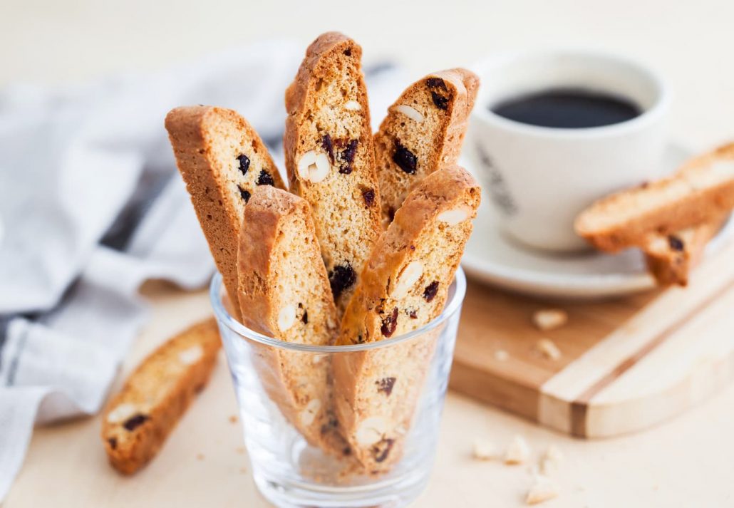 A cup full of Italian biscotti, and a cup of coffee.