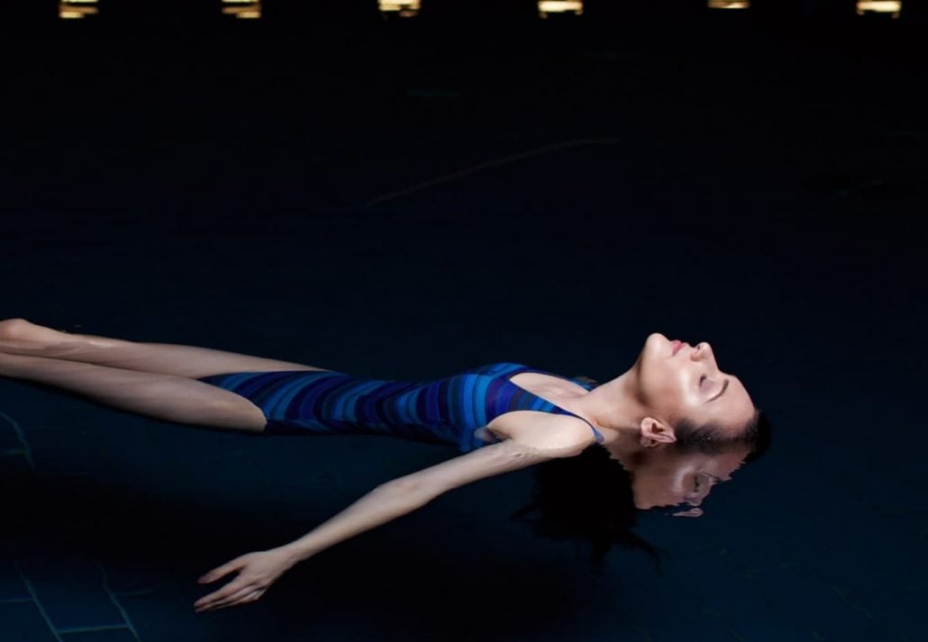 A woman floating in a sound pool in a dark room, Liquidrom spa Berlin