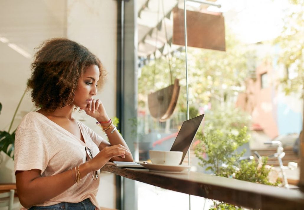 Young woman working on her laptop in a cafe.