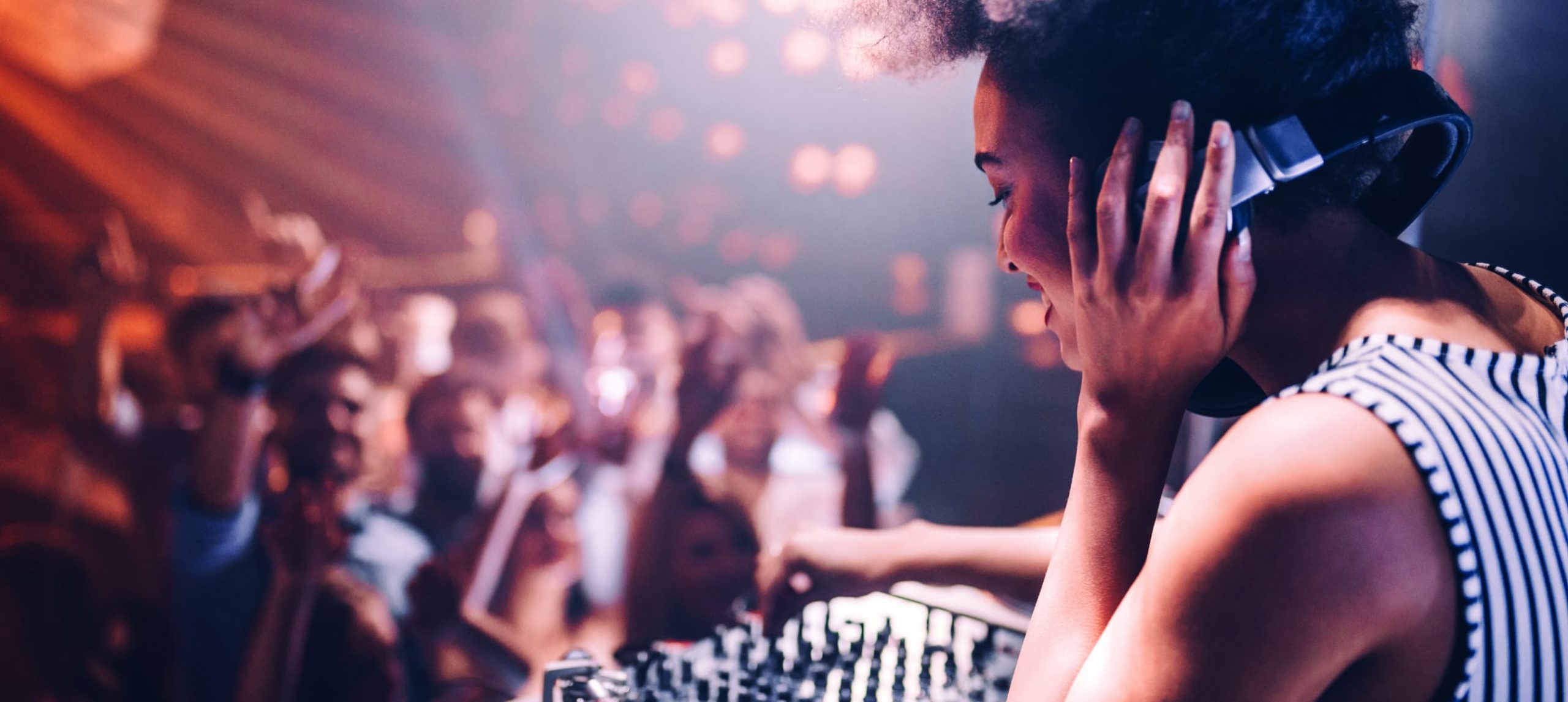 Young female DJ during her set at a nightclub party