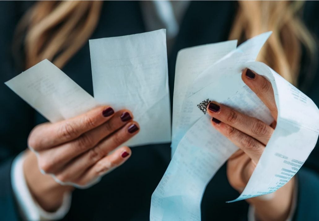  A female holding a couple of receipts