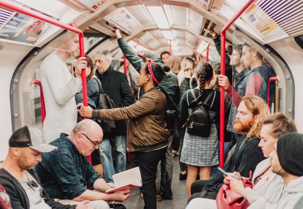  People sitting and standing in the London Tube