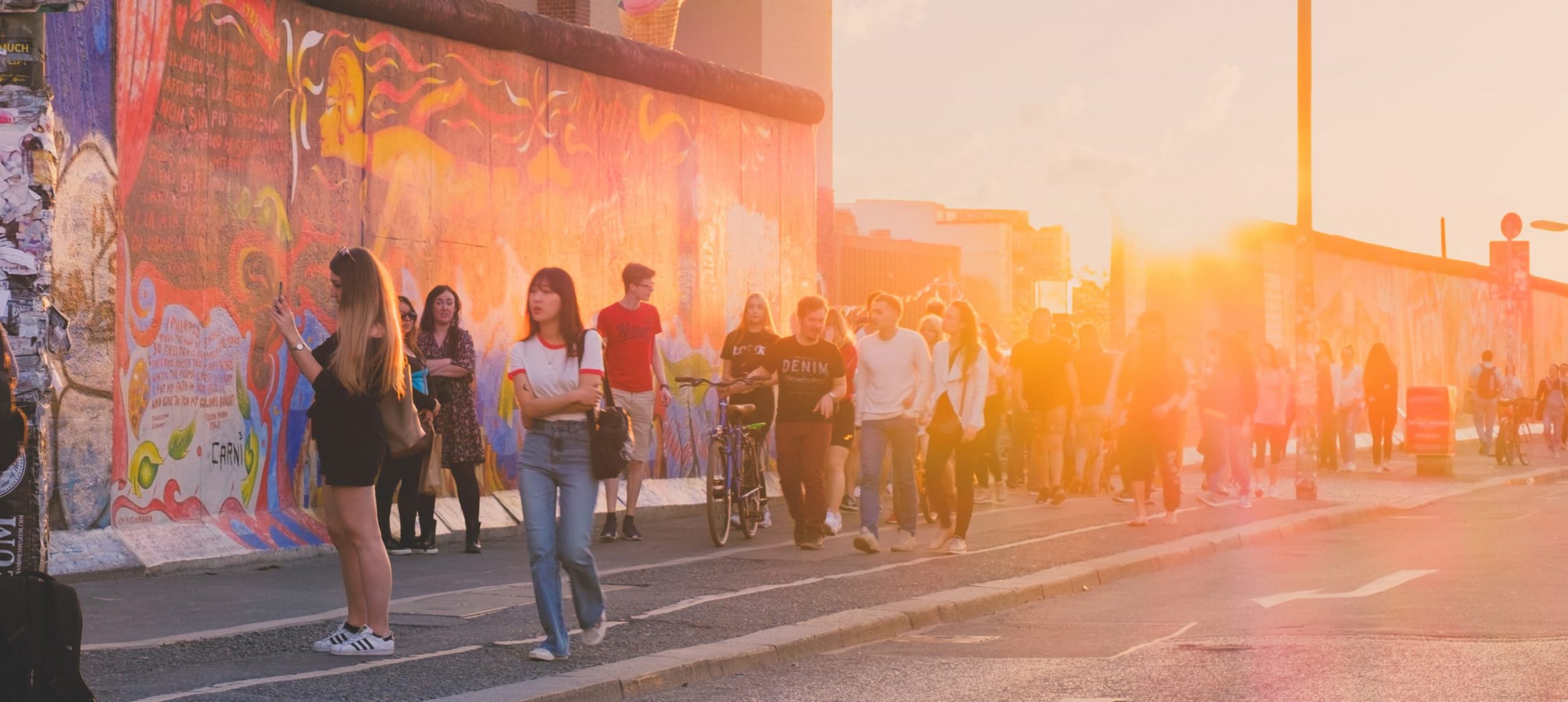 People in front of the East Side Gallery, Berlin, Germany.