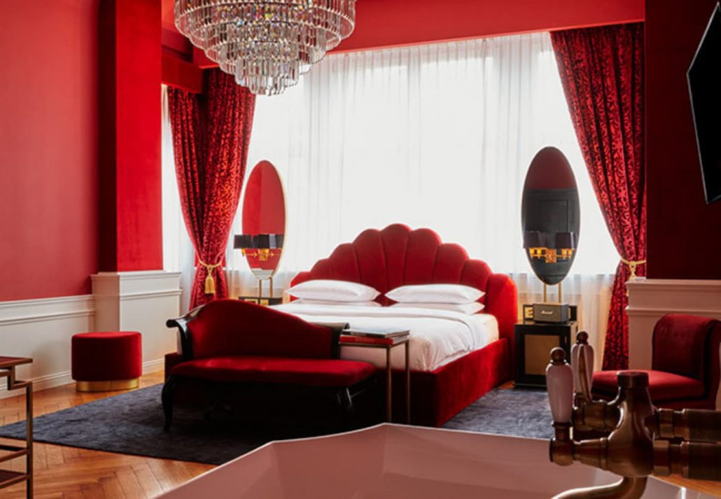 A suite with red walls and red bed in the Berlin Provocateur Hotel