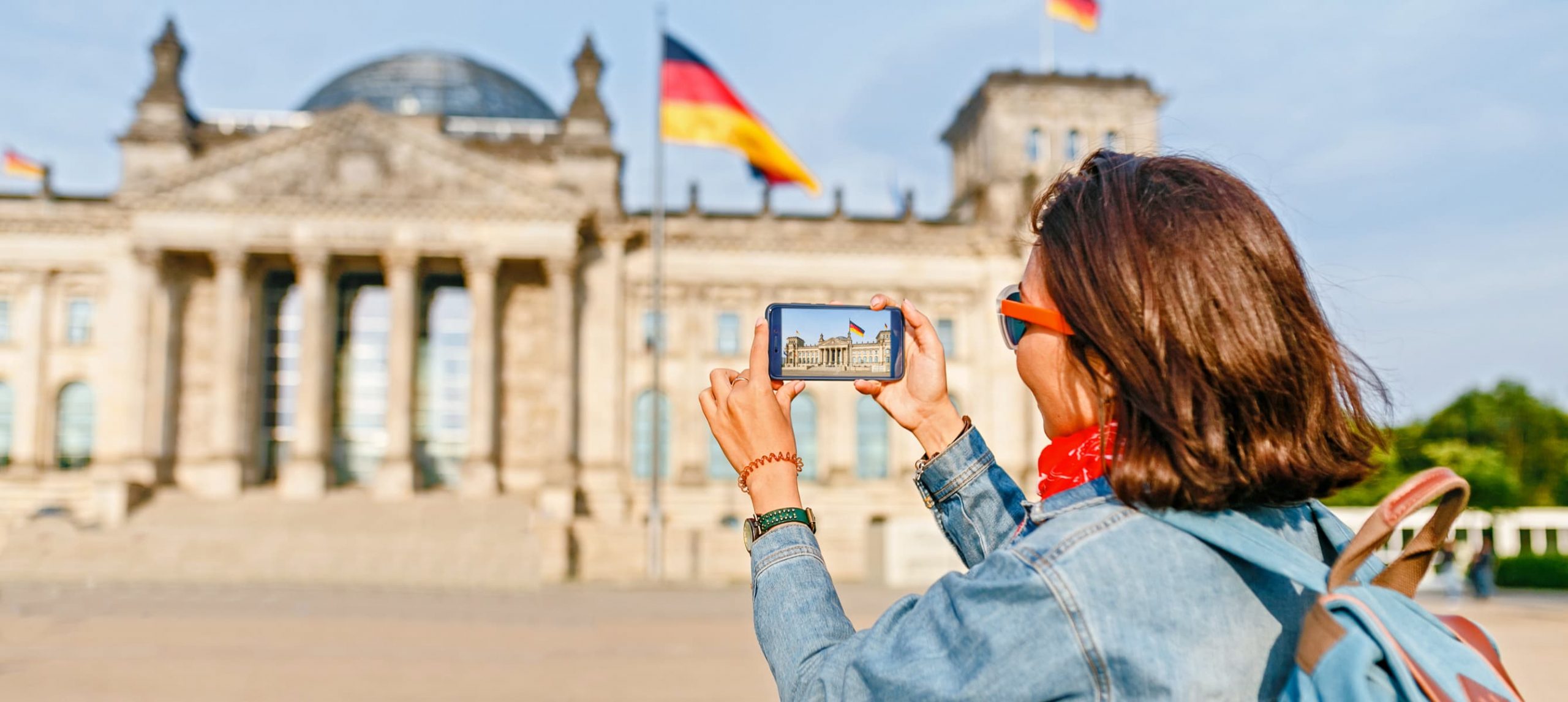 A female traveler taking a photo of Band des Bundes in Berlin