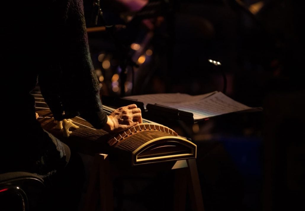 An artist playing a jazz instrument in a dark room