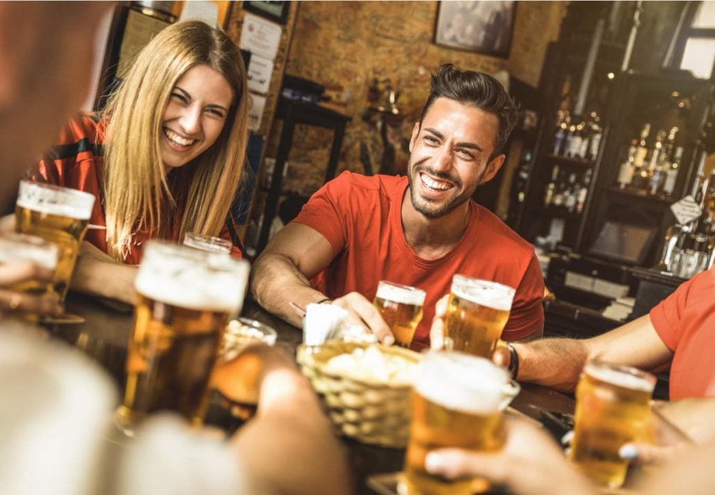 A group of people drinking beer at a bar