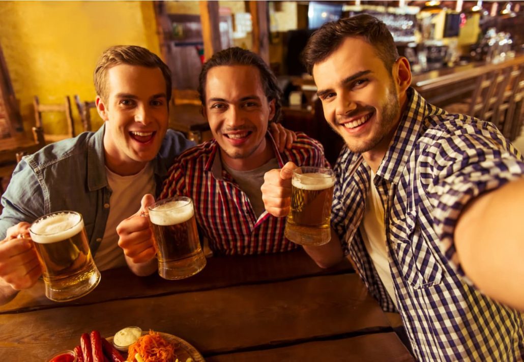 A group of men taking a selfie with beers in their hands