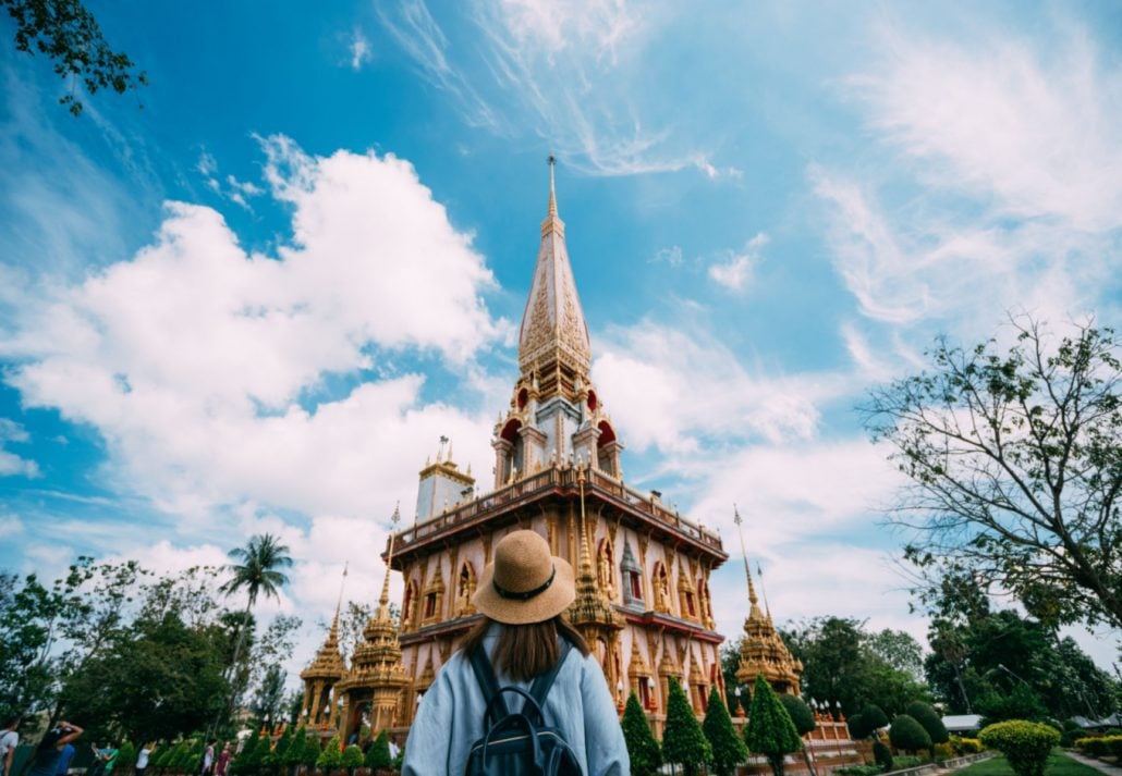 A woman viewing a Thai temple in Phuket