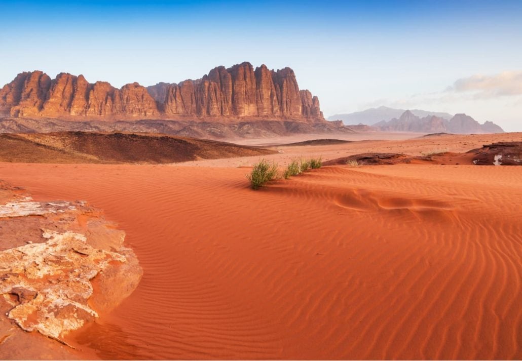 Orange sand dunes with a mountain in the distance, Wadi Rum