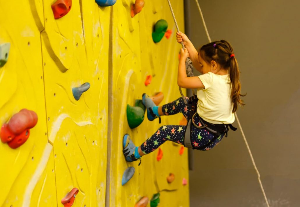 A girl climbing a climbing wall
