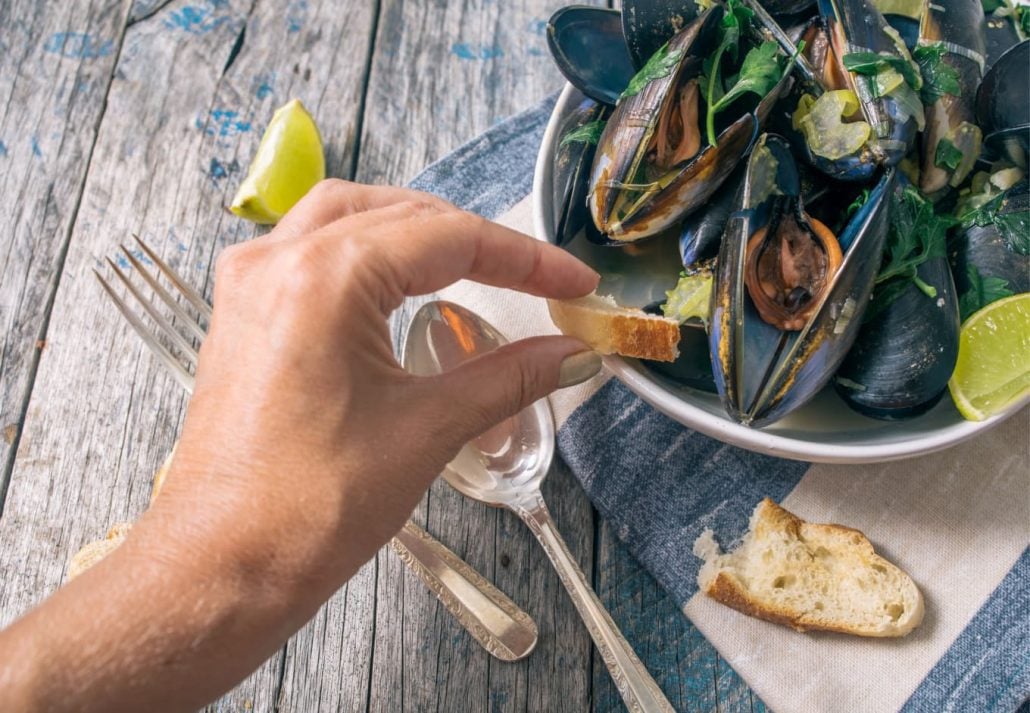 A person taking clams to eat