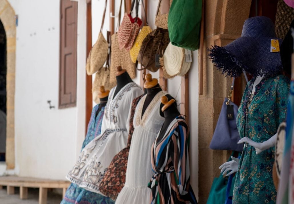 An outdoor shop with clothes displayed on the street