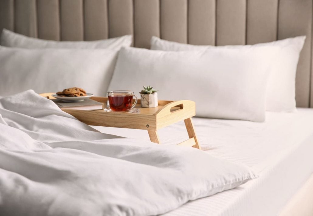 A food tray on a bed in a hotel room