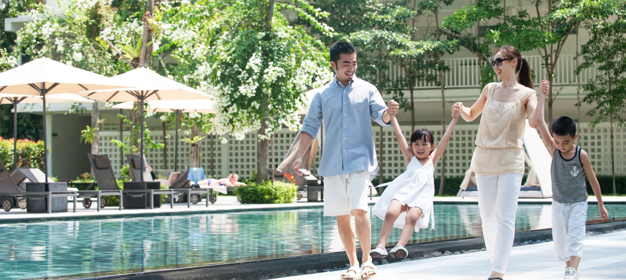 Asian family happily enjoying their stay at a lush hotel.