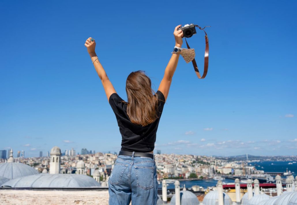 A girl on the rooftop terrace facing the panoramic view of Istanbul