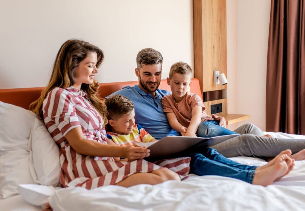 A family lying on the bed and reading stories