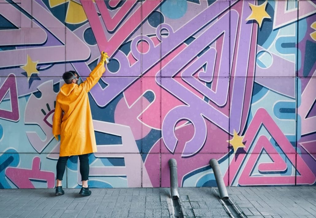 instagrammable-places-hong-kong-artlane | CuddlyNest Travel Blog Street artist painting colorful graffiti on wall. Modern urban art concept