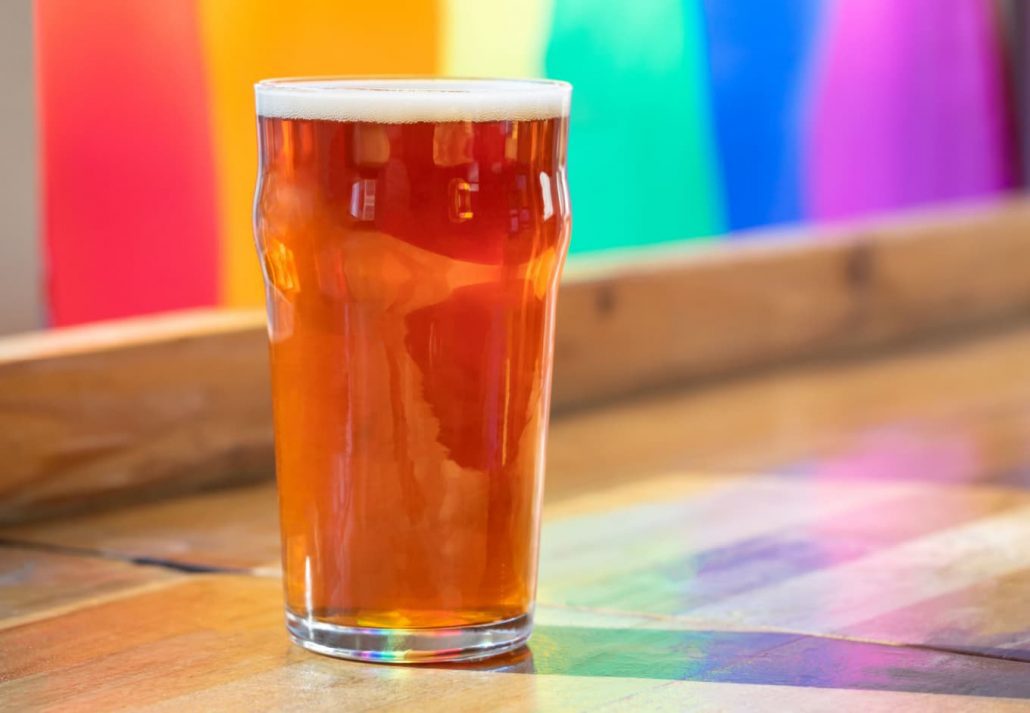 A glass of beer in front of a rainbow wall