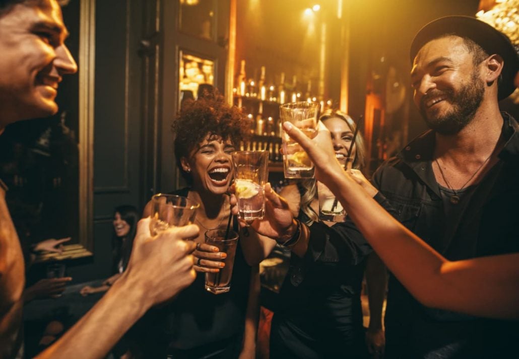 A group of friends laughing and enjoying their drinks