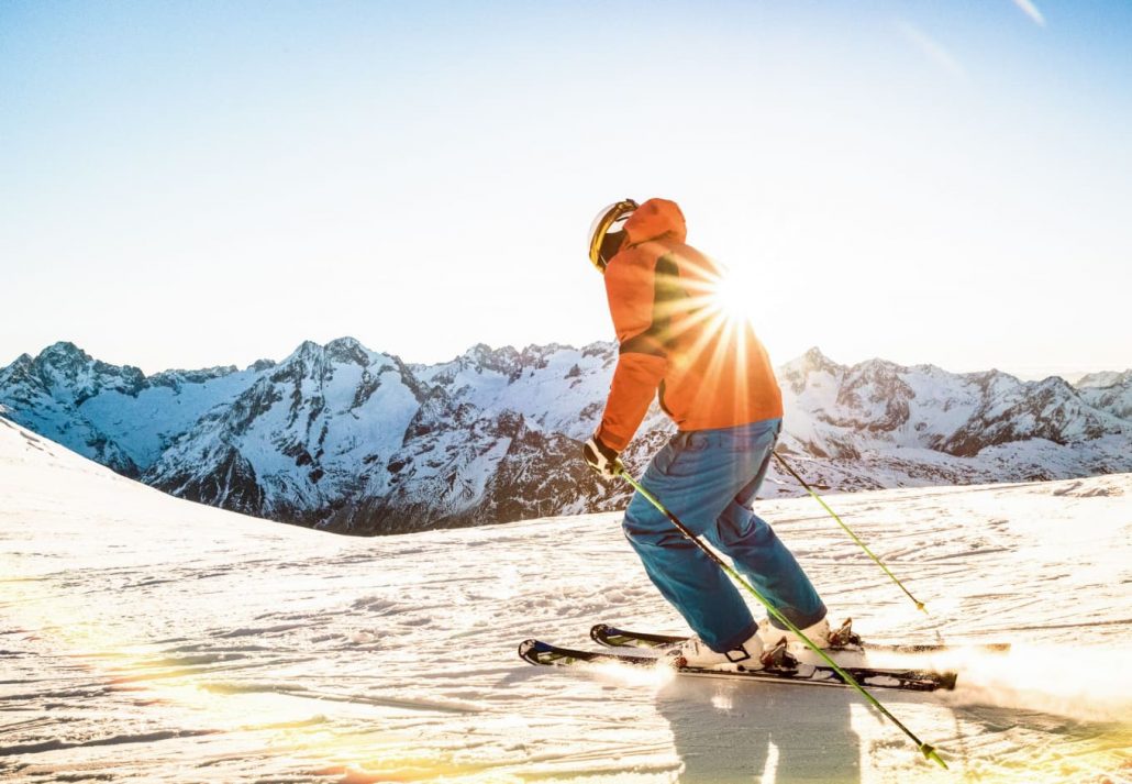 skiing-in-greece-1 | CuddlyNest Travel Blog A man skiing down the mountain with sunrise in the background