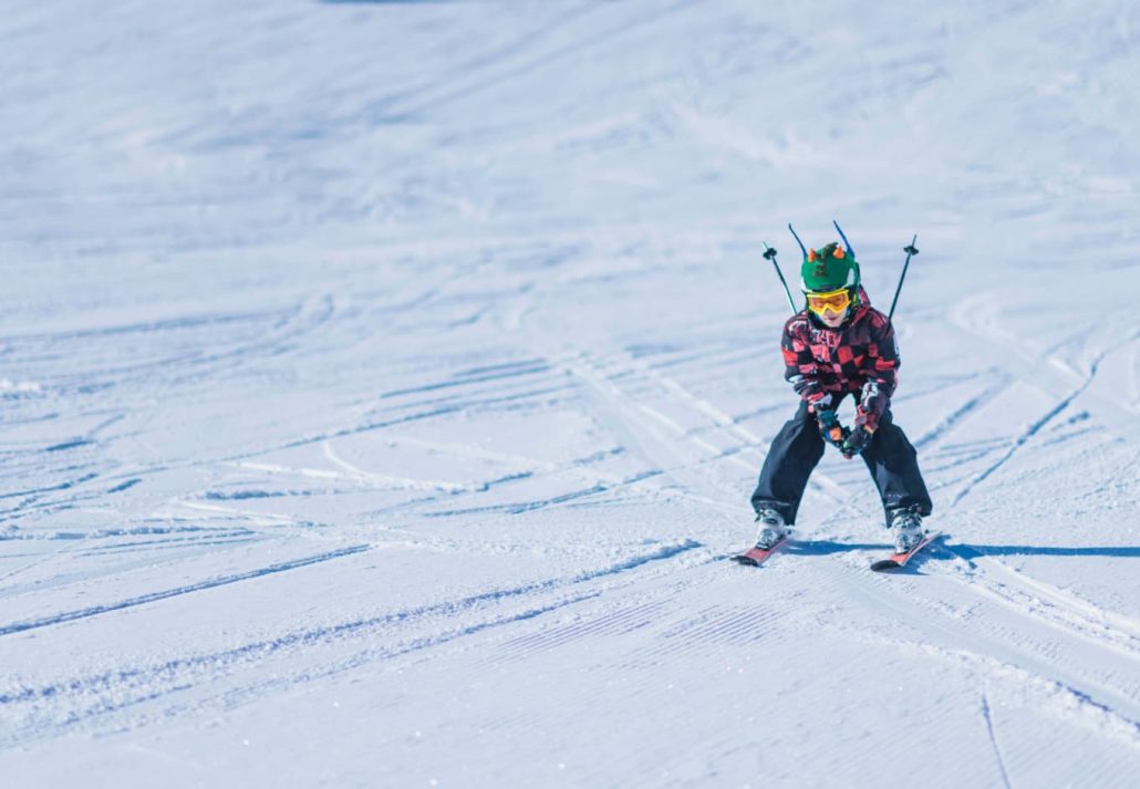 A little boy skiing and looking at the camera